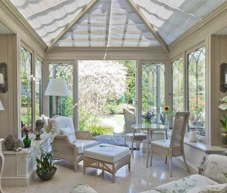 a living room filled with lots of furniture and windows covered in white covering over it