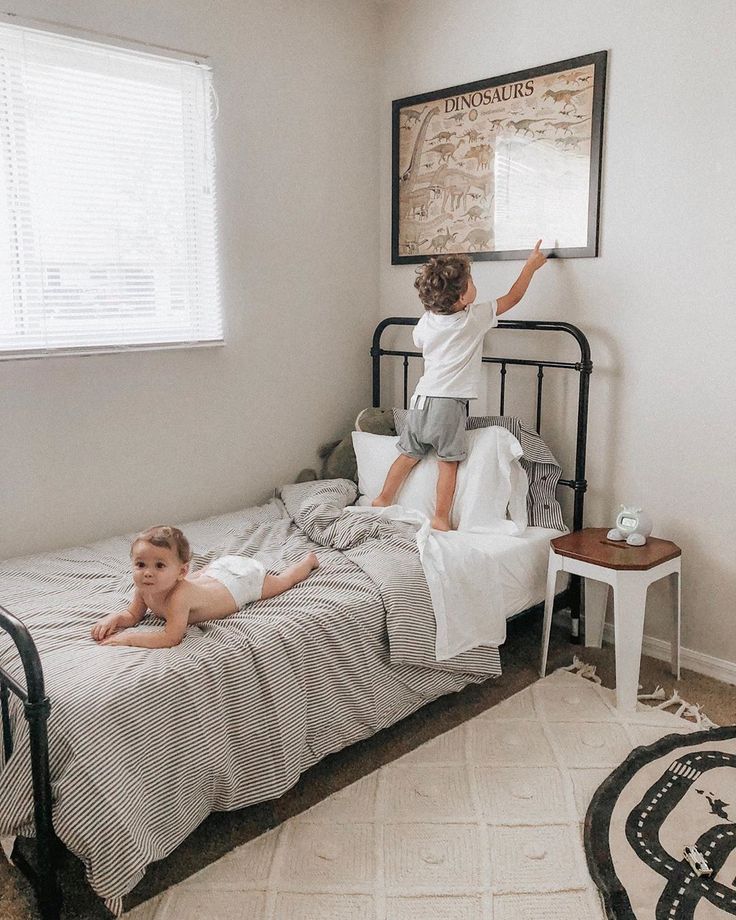 two children playing on a bed in a bedroom