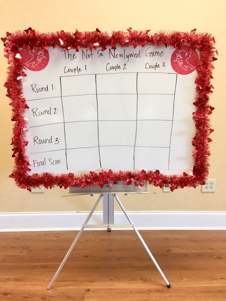 a white board with red tinsel around it on a tripod in front of a wall