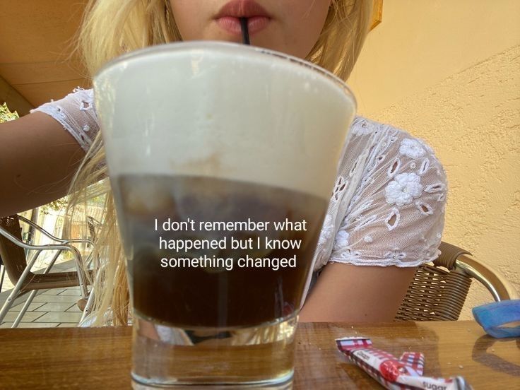 a woman sitting at a table with a glass in front of her and the caption, i don't remember what happened