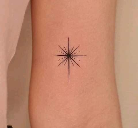 a small star tattoo on the right side of the arm, with an arrow in the center