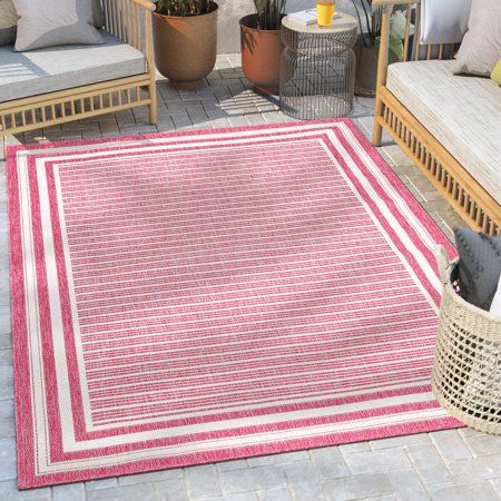 a red and white rug sitting on top of a patio