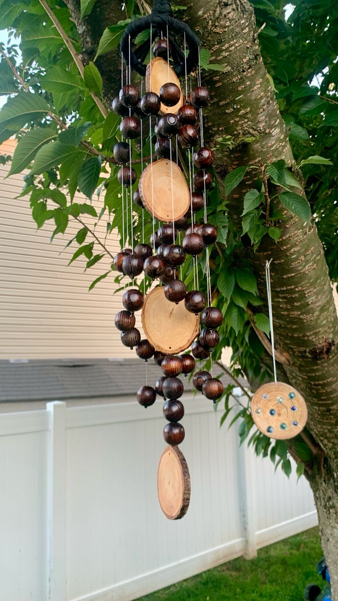 a wooden wind chime hanging from a tree