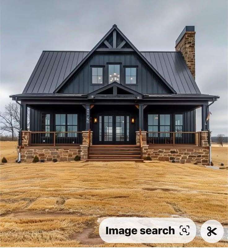 a black and brown house in the middle of a field