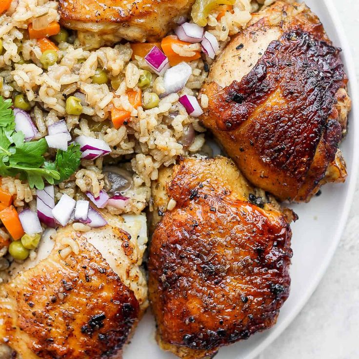 chicken, rice and vegetables on a plate with garnished with cilantro