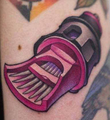 a close up of a person's arm with a tattoo on it and a toothbrush