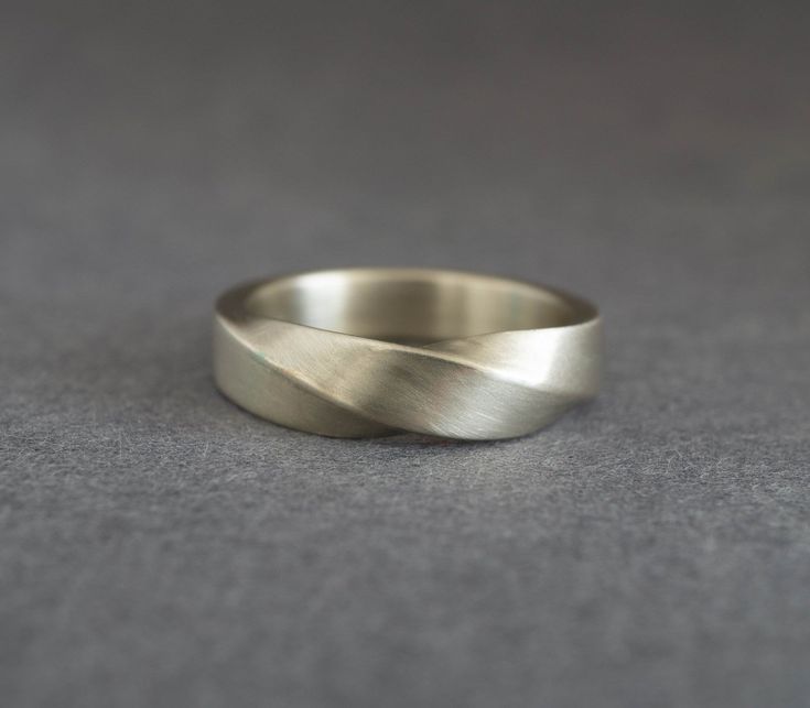 two silver rings sitting on top of a gray surface