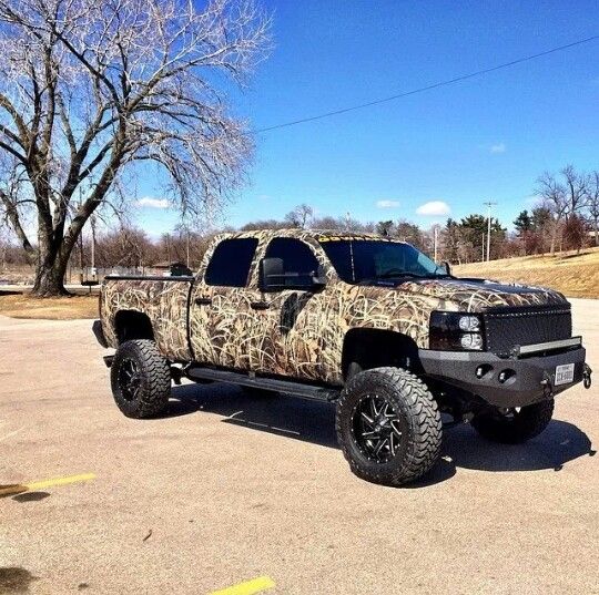 the truck is camouflaged with black wheels and tires