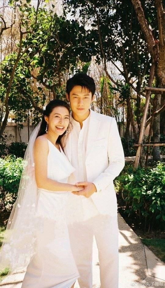 a man and woman in wedding attire posing for a photo