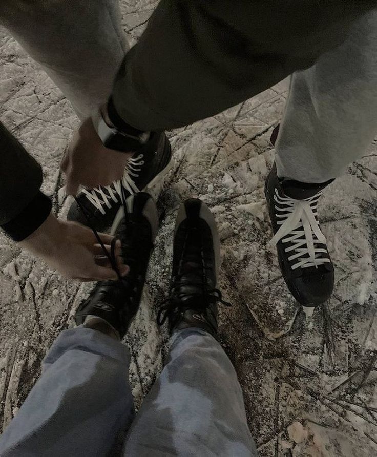 two people standing next to each other wearing black and white shoes with laces on them