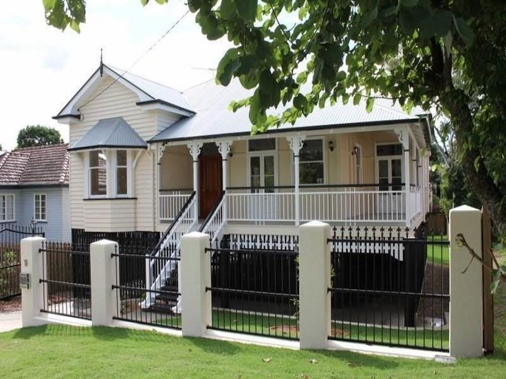 a white house with a black fence in front of it