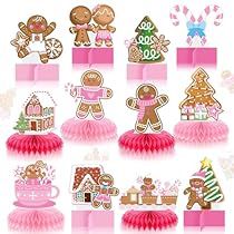 a bunch of gingerbread cutouts on top of some pink tissue paper with bows