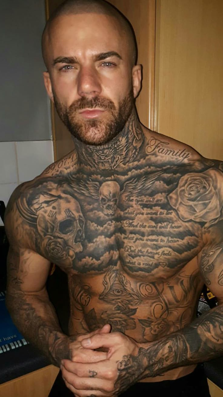 a man with tattoos on his chest posing for the camera