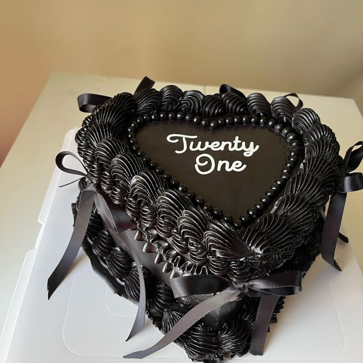 a heart - shaped cake with the words twenty one on it is sitting on a white box