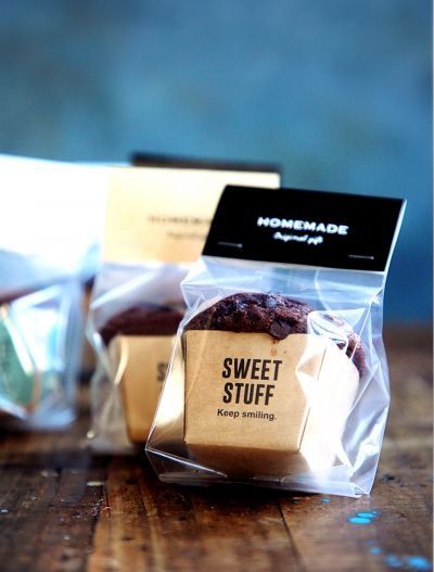 two bags of cookies sitting on top of a wooden table next to one bag with the label sweet stuff