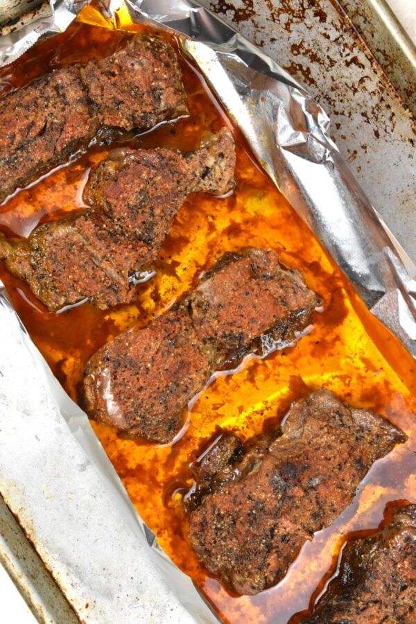 meatloaf covered in brown sauce on top of tin foil