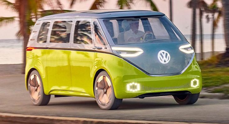 a green and blue vw bus driving down the road next to palm tree lined beach