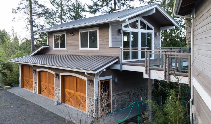 a house with two garages and a balcony on the second floor is shown in this image