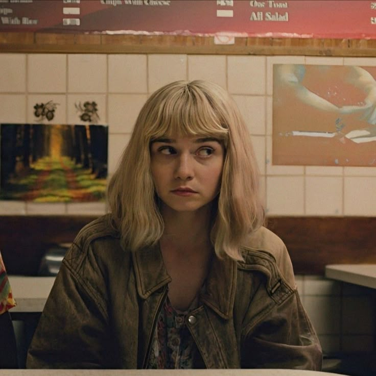 two women sitting at a table in a restaurant, one with blonde hair and the other without