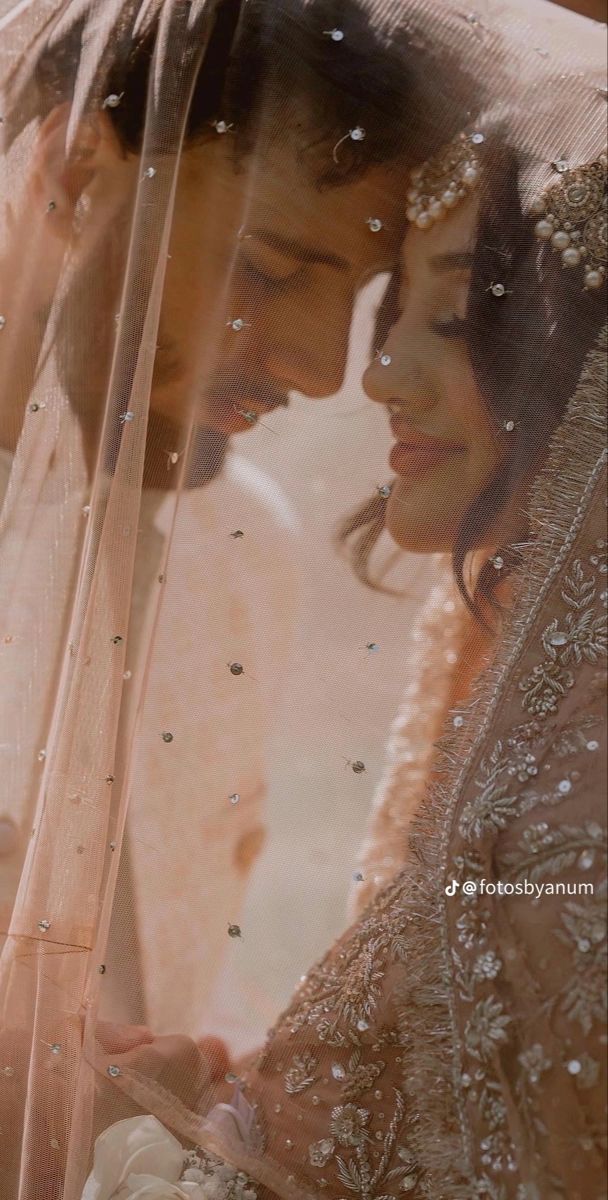 two women standing next to each other under a veil