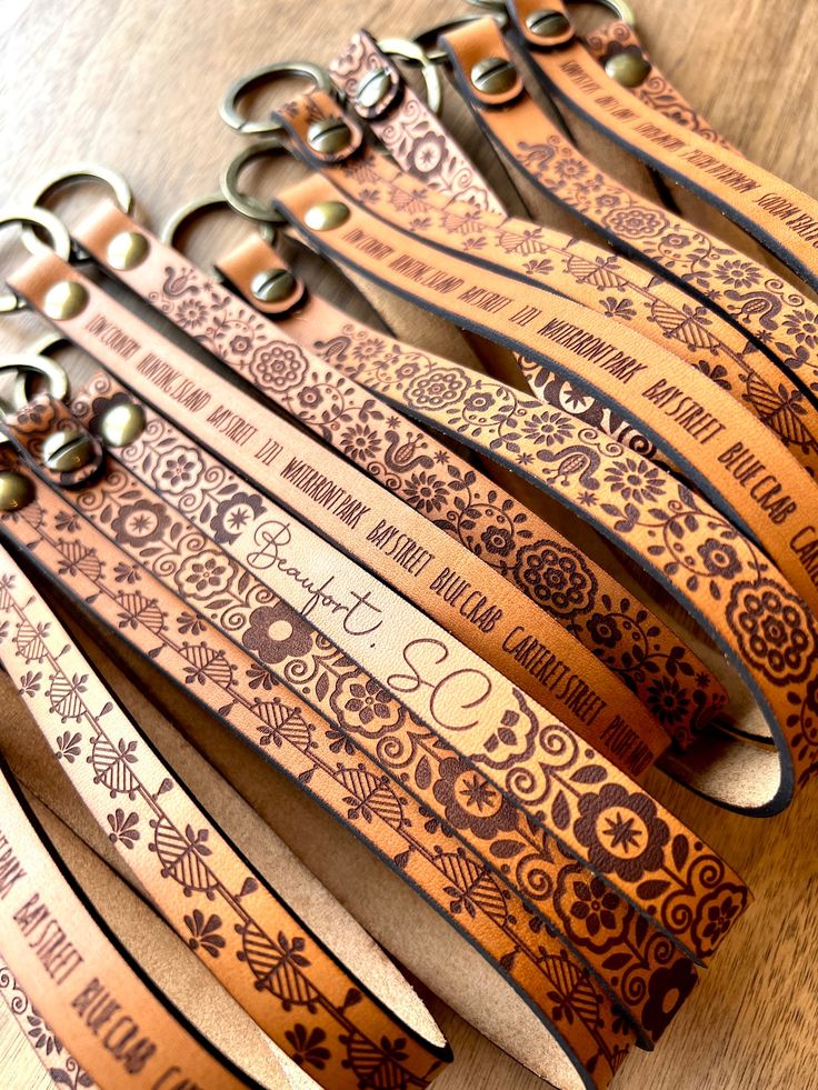 several pairs of scissors are lined up on a table with the names and numbers engraved on them