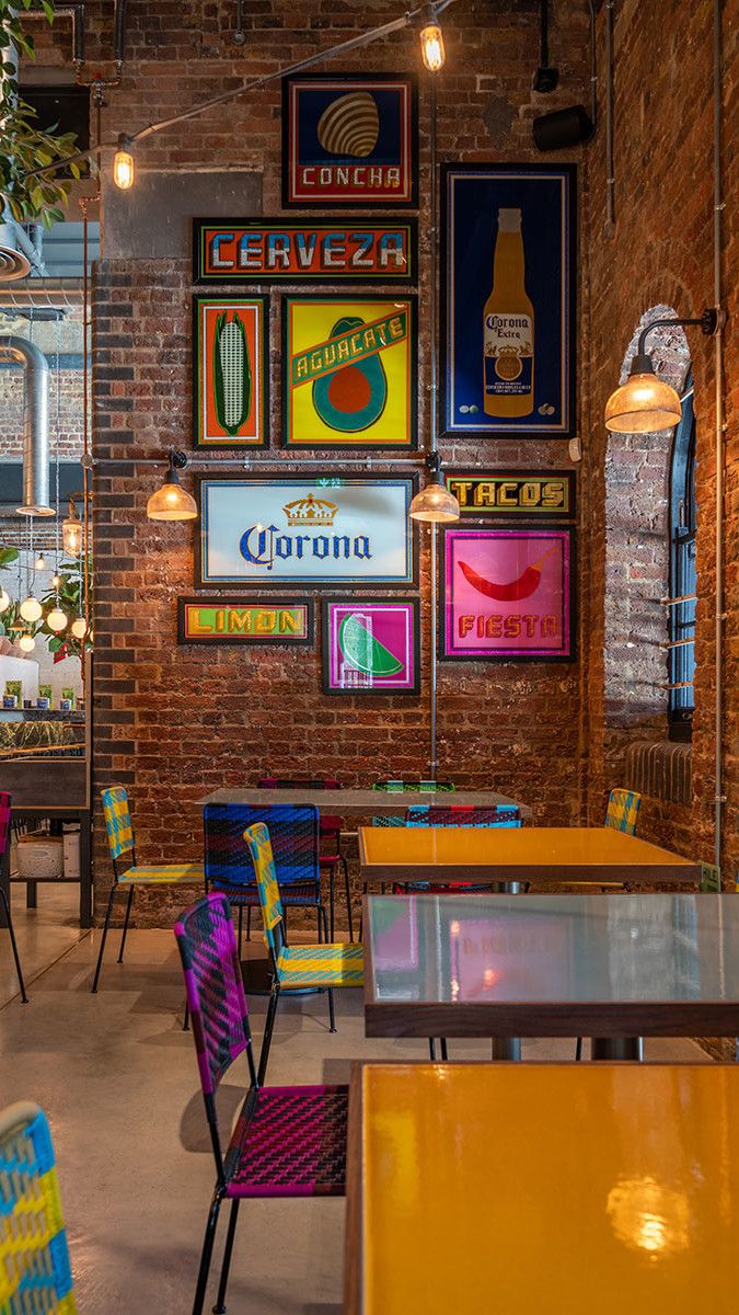 the interior of a restaurant with colorful tables and chairs