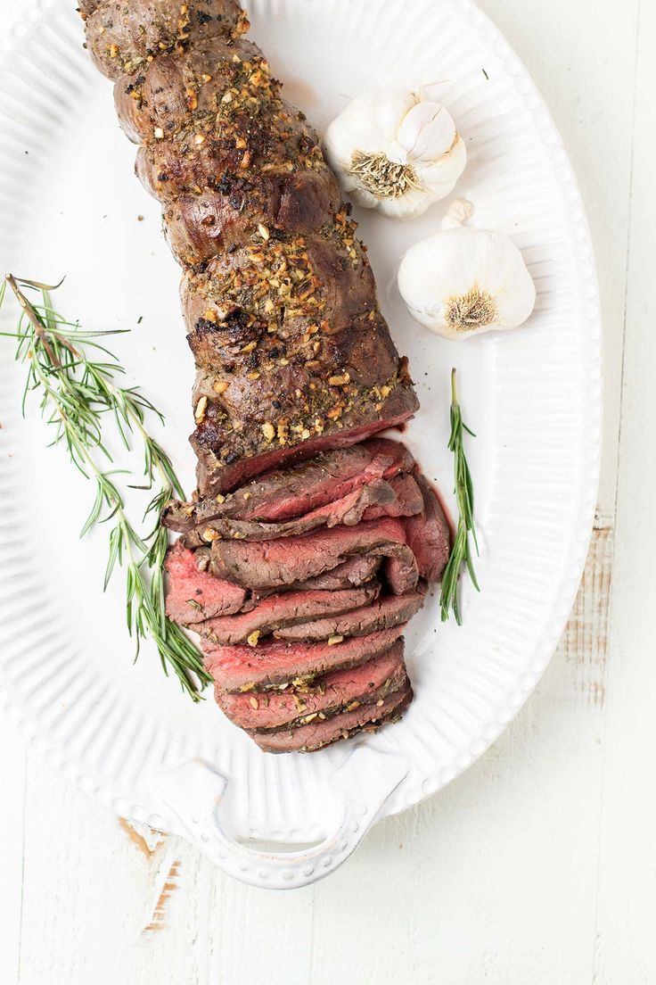 steak with herbs and garlic on a paper plate