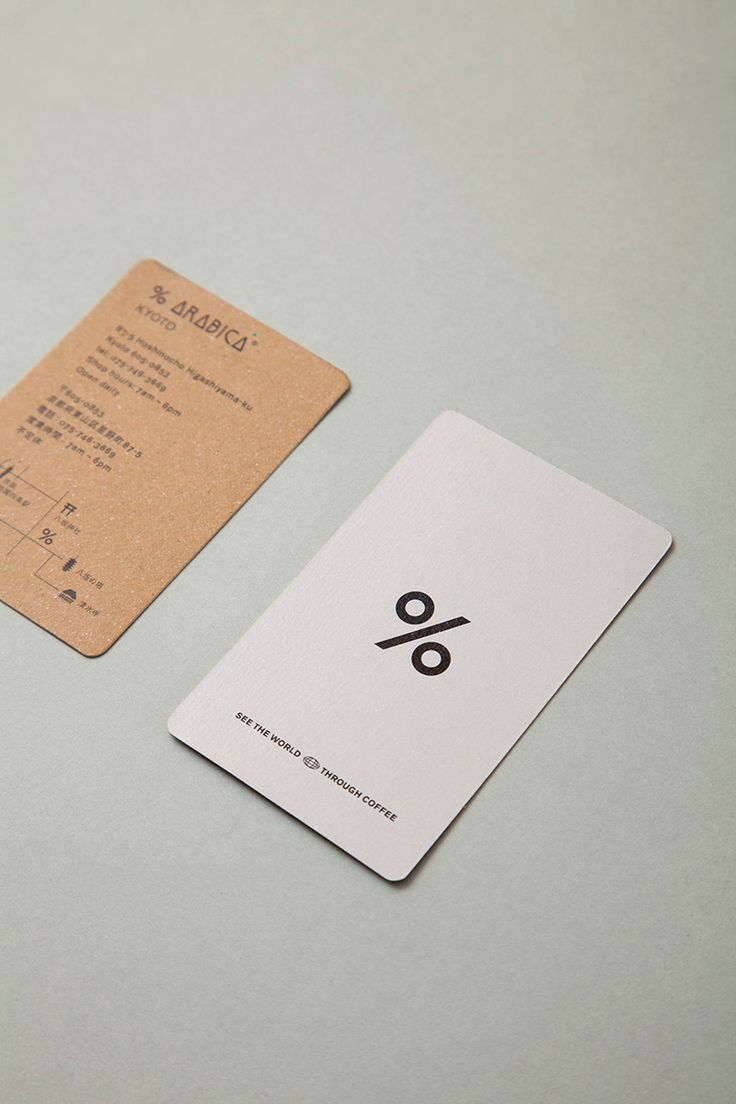 a white and black business card sitting on top of a gray table next to a brown price tag