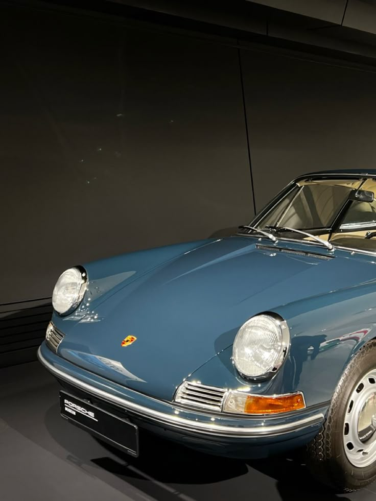 an old blue sports car is on display