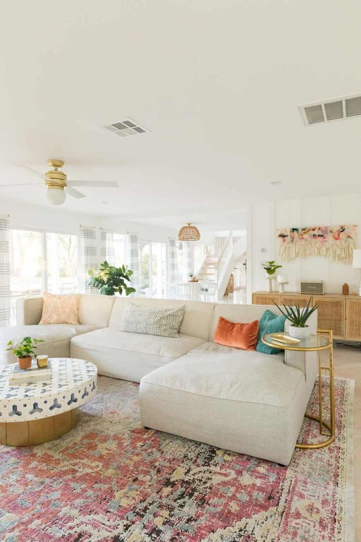 a living room filled with furniture and lots of pillows on top of a colorful rug