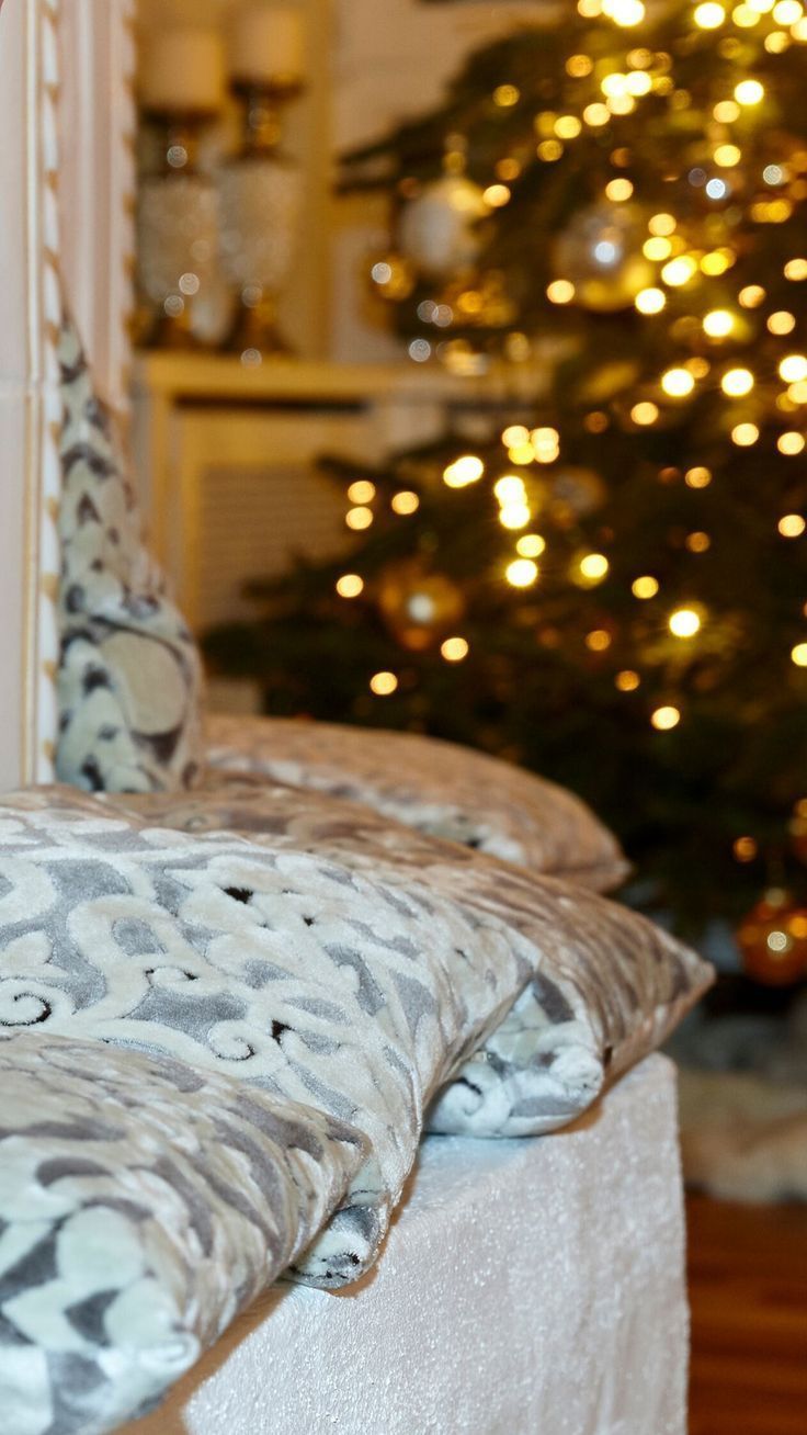 a bed with pillows and a christmas tree in the background