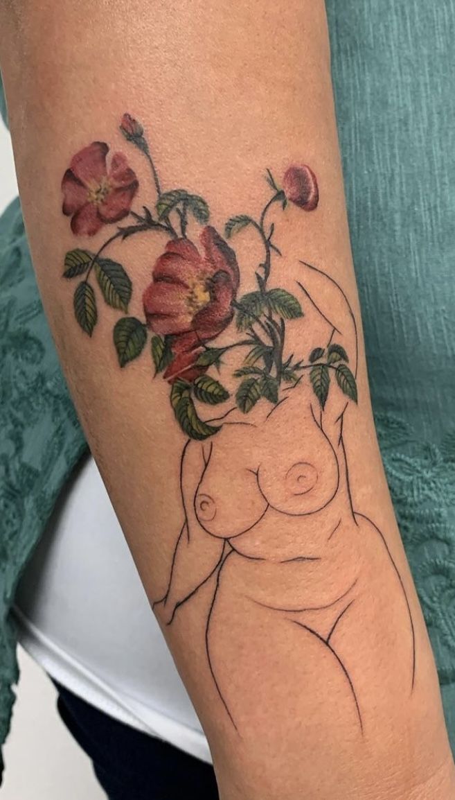 a woman's arm with flowers on it and a drawing of a breast in the center