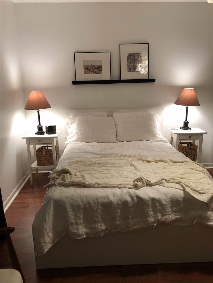 a bed with two lamps on either side of it