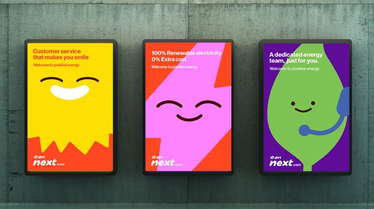 three posters on the side of a building with different colors and shapes, each featuring an image of a smiling face