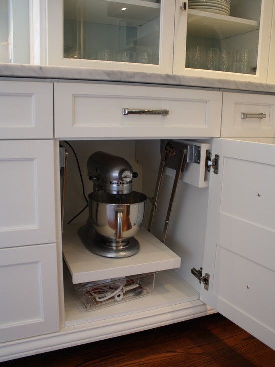 an open cabinet in a kitchen with white cabinets