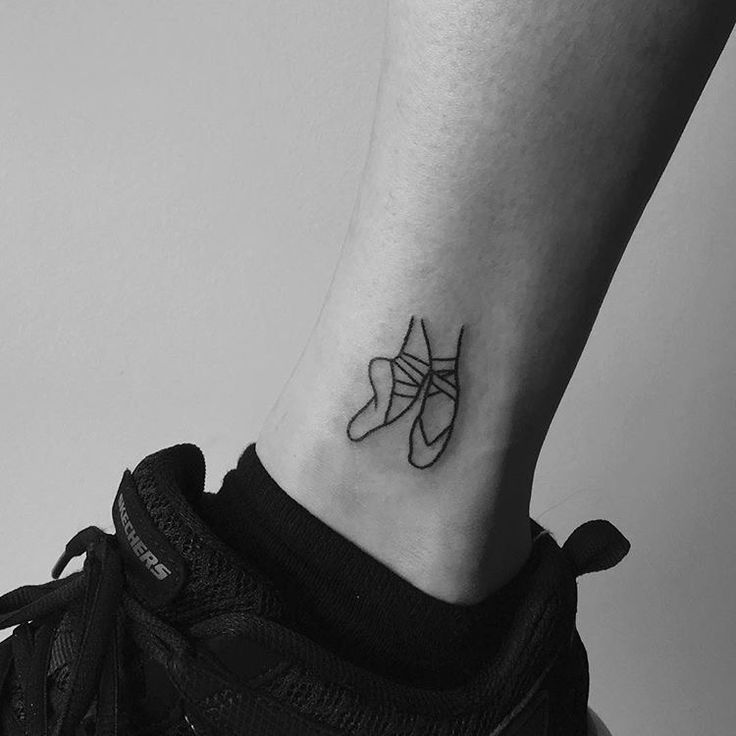 a black and white photo of a person's foot with a shoe tattoo