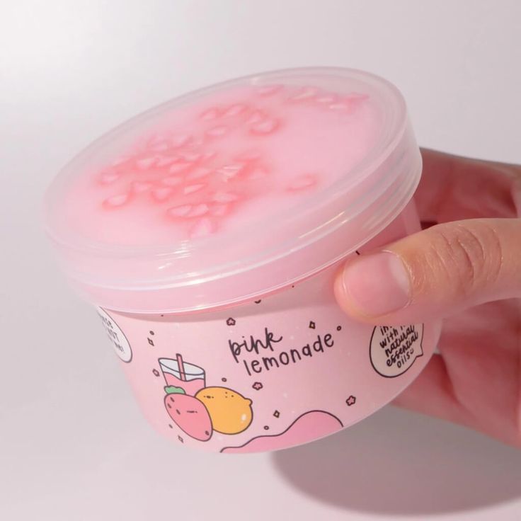 a hand is holding a pink ice cream container