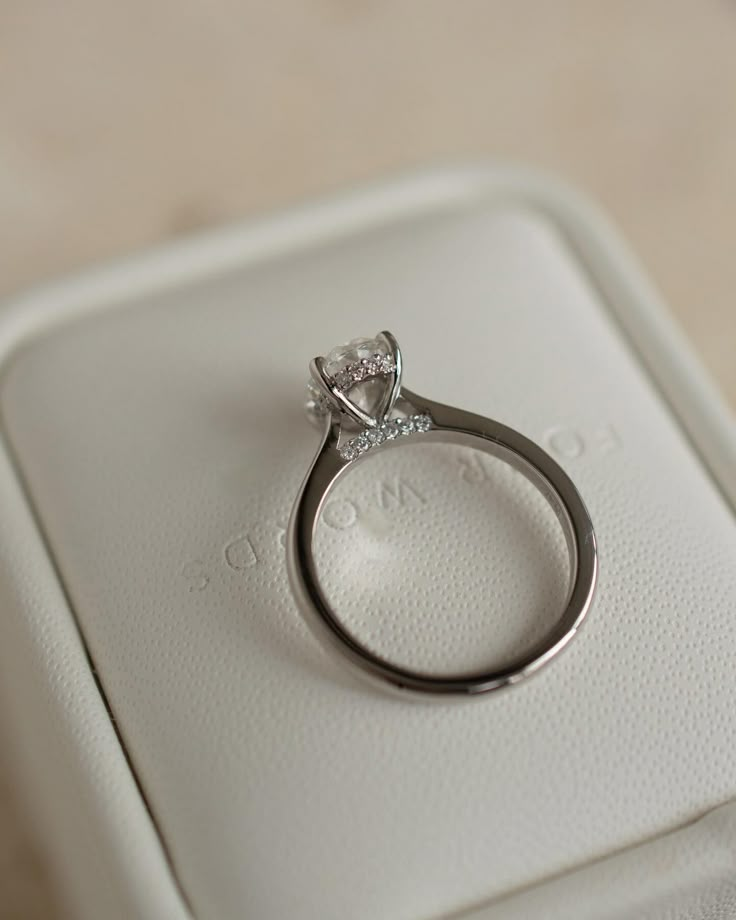 a diamond ring sitting on top of a white box