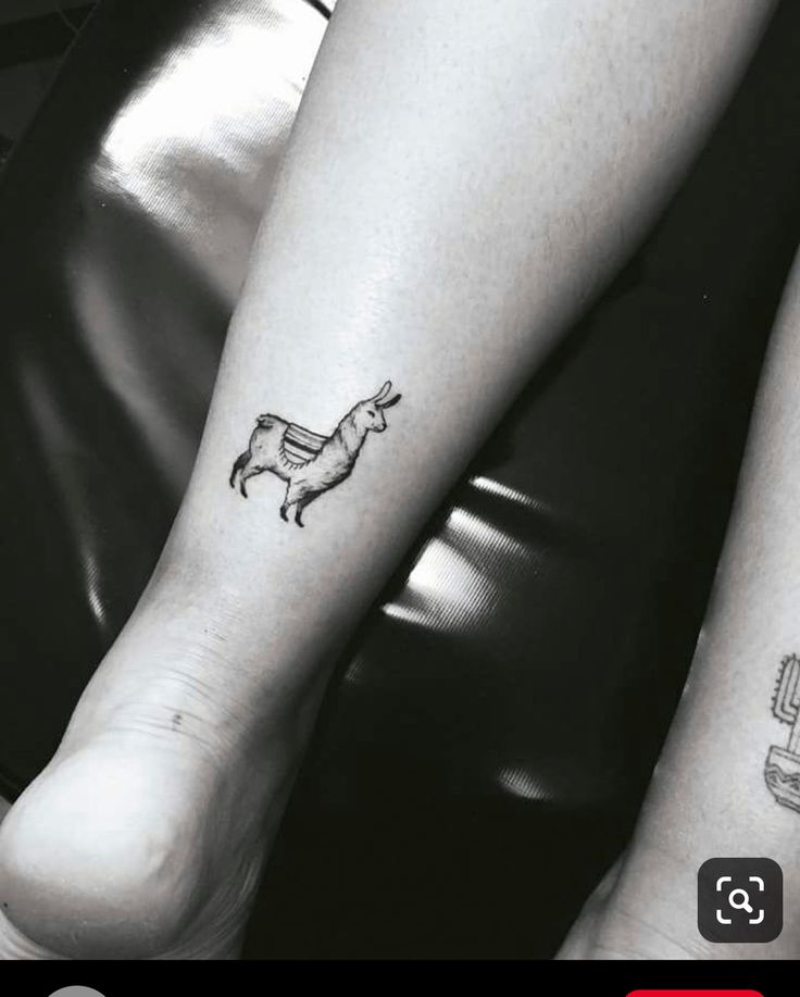 two people with tattoos on their legs sitting next to each other and one has a dog tattoo on it's leg