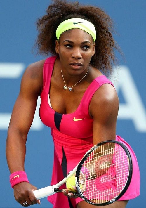 a woman holding a tennis racquet on top of a tennis court with a ball in her hand