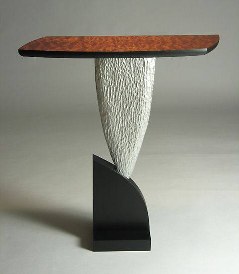 an artistically designed table with a wooden top and curved base, against a white background