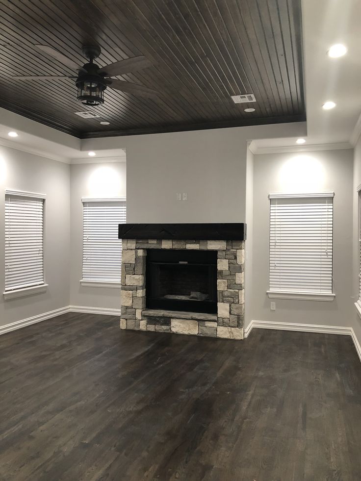 an empty living room with wood floors and a fireplace