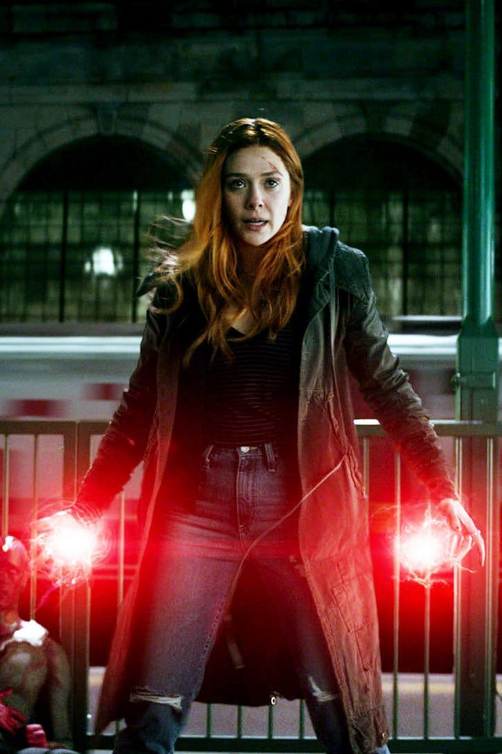 a woman standing in front of a fence with two red lights on her hands,