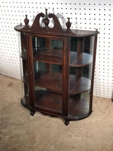 an antique wooden display case with glass doors