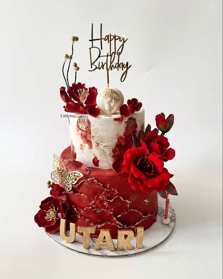 a red and white birthday cake with flowers on it