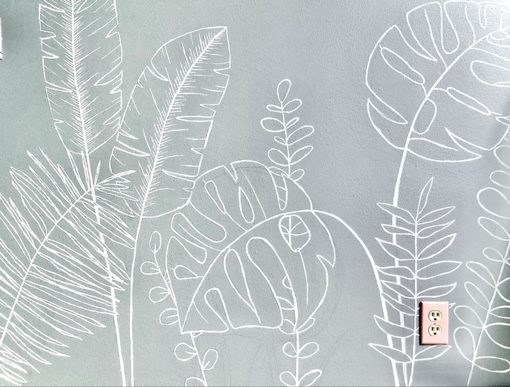 a white drawing on a wall with a light switch in front of it and plants drawn on the wall