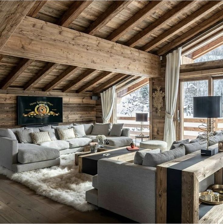 a living room filled with furniture and wooden walls