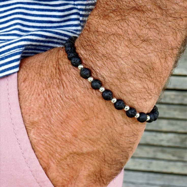 Men's bracelet made of lava stone and stainless steel beads. This classic timeless bracelet will go great with a t-shirt or your favorite suit. It is strung on a nylon stretch band, making it easy to slip over your hand. We use natural stone, so each bead and bracelet is unique. DETAILS Lava Stone (6mm) Stainless steel beads Elastic nylon strap The bracelet comes in a fabric jewelry pouch. EFFECT The matte lava stone grounds and gives strength and endurance. More men's bracelets: https://www.etsy.com/de/shop/GluecksbringerinShop?ref=search_shop_redirect&page=1#items My Shop: https://www.etsy.com/de/shop/GluecksbringerinShop?ref=search_shop_redirect Diy Armband, Schmuck Diy, Men's Bracelets, Stretch Band, Stretch Bands, Men's Bracelet, Minimalist Bracelet, Lava Stone, Fabric Jewelry