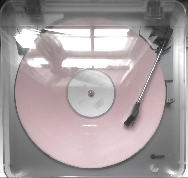 a pink record player in a clear plastic case