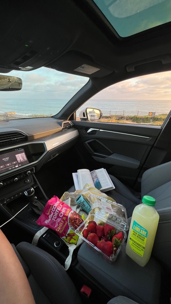 the interior of a car with food and drinks on the back seat in front of it